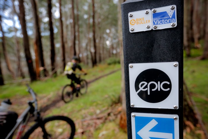 Australian Alpine Epic Trail sign with mountainbikers in the distance